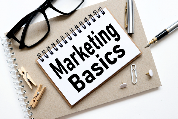A notebook, a pen and other tools you need to start writing marketing basics.